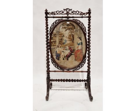 19th century rosewood firescreen, the frame with pierced carved panels and barleytwist supports holding an oval needlework cl