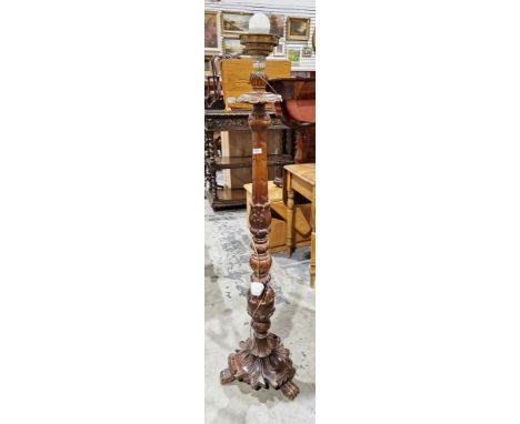 Early 20th century wooden standard lamp, the column ornately carved with acanthus leaves, raised on a foliate carved base wit