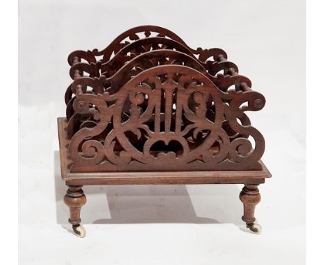 19th century mahogany four-section canterbury, the scrolling pierced panels united by turned spindle, raised on turned legs w
