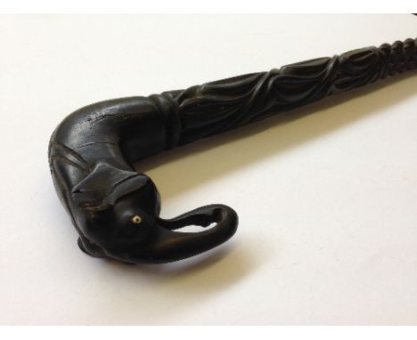 A carved ebony walking stick with elephant handle.
(r14)
