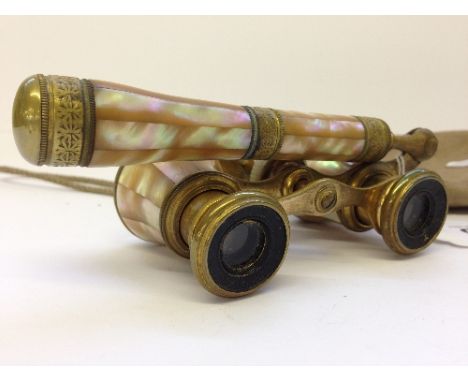 An early 20th century mother of pearl cased pair of opera glasses by Iris, Paris with adjustable handle.