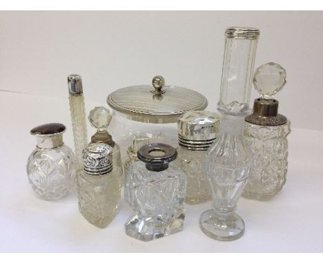 A collection of various silver mounted cut glass dressing table pots and scent bottles together with a silver lidded cut glas