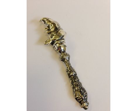 A silver babies rattle with Jester finial.