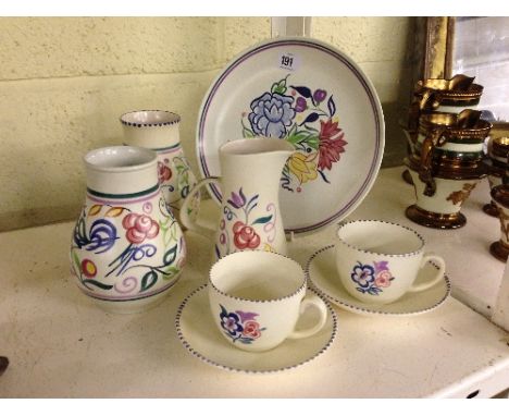 A pair of Poole Pottery vases decorated in the LE pattern together with a pair of cups and saucers, decorated in the KG patte