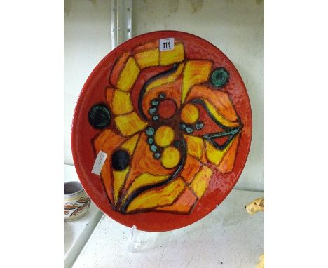 A Poole Pottery Delphis charger, shape 54, decorated in an abstract design in tones of blue, yellow and orange (hairline).