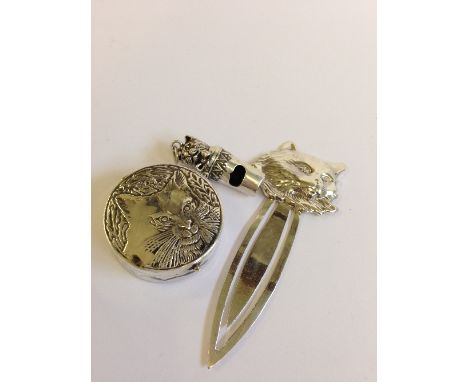 A silver page marker with cat's head decoration together with a small whistle decorated with a Cat and a pill box with cat fa