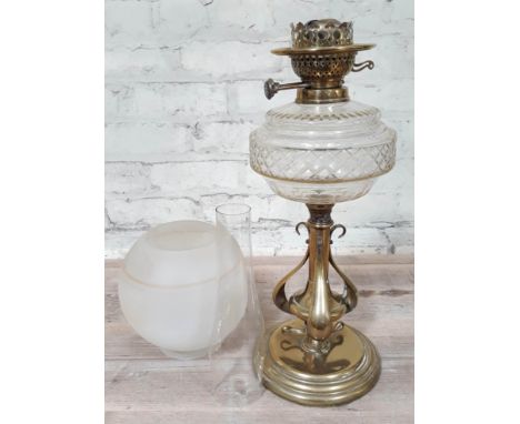 A brass Art Nouveau style oil lamp with glass shade and flu, height 69cm  Condition: glass shade has been repaired, glass fun