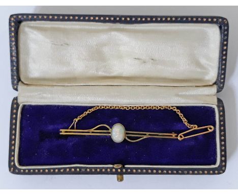 A 9ct gold bar brooch set with an opal cabochon, marked '9ct', length 5cm, gross wt. 2.6g, with associated box.  