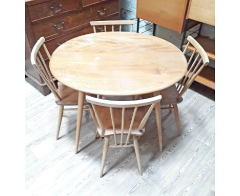 An Ercol light elm and beech oval dining table with lower spindle tier and four chairs. 