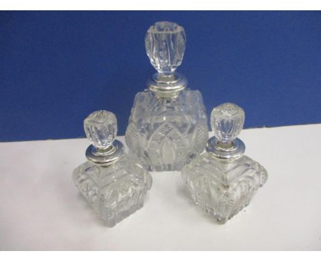 Three cut glass and silver rimmed dressing table bottles 