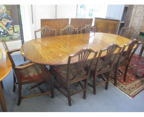 An early 20th century mahogany triple pedestal dining table with two extra leaves and a set of eight pierced splat back, tape