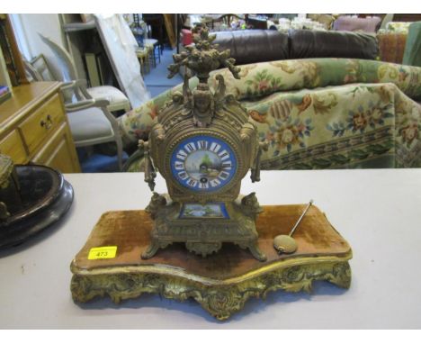A French 19th century gilt metal cased mantle clock with pictorial porcelain dial having Roman numerals, with pendulum and gi