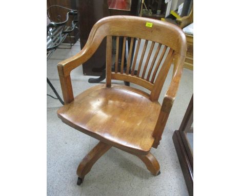 An early 20th century light oak revolving desk chair 