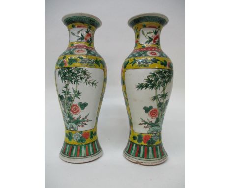 A pair of early 20th century Chinese vases of ovoid form decorated with panels of flowers and bamboo, on a yellow ground, wit