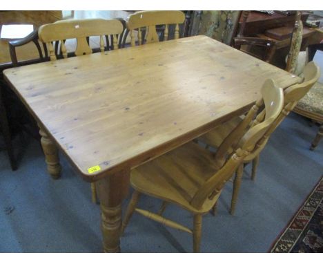 A pine kitchen table having an inset drawer and turned legs together with four splat back chairs 