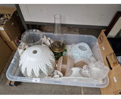 A box of glass light shades and a Victorian oil lamp. 