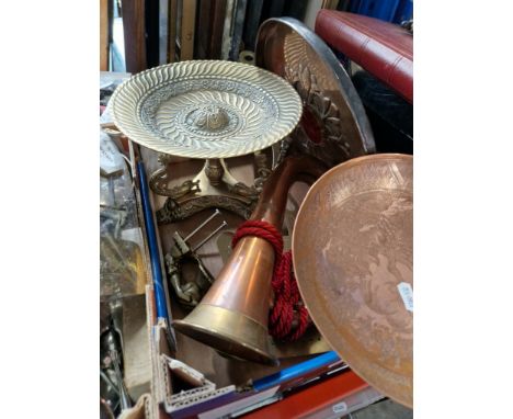 A box of copper and brassware including Arts & Crafts copper and enamel plaque, brass dolphin stand, bugle, brass cream skimm