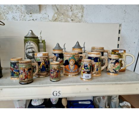 A collection of 13 ceramic steins. 