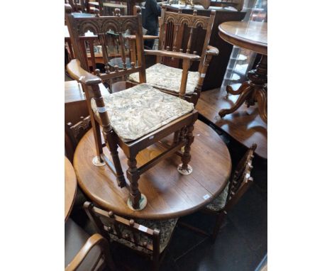 An Ercol elm extending dining table and six chairs including two carvers. 