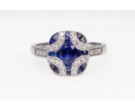 A modern 18ct white gold, sapphire and diamond panel ring, the rounded-oblong head centred with an oval mixed-cut sapphire wi