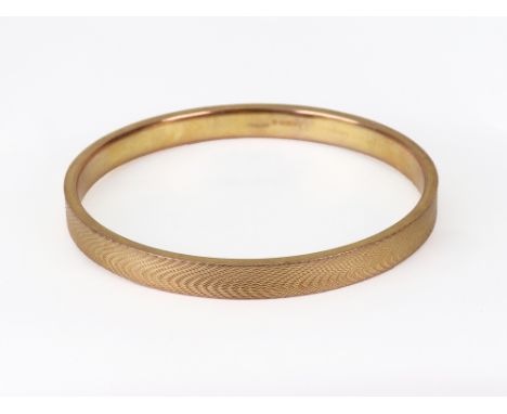 An early 20th century 9ct rose gold hollow engine turned slave bangle of rectangular section, Chester 1922, 13.2g