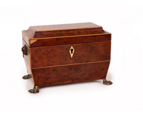 A Regency burr yew tea caddy, circa 1810, of sarcophagus form and with boxwood stringing, the hinged cover enclosing two lidd