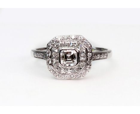 A modern diamond cluster ring, the cut-corner panel rub-over set at the centre with an ascher-cut diamond approx. 0.38cts, wi