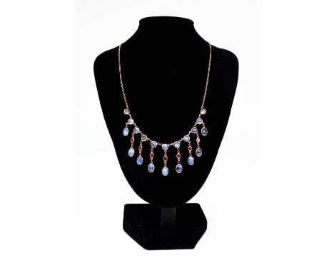 A modern 9ct gold, ruby and moonstone fringe necklace, the front designed as a row of 11 round cabochon moonstones suspending