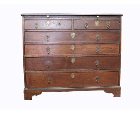 A George III oak chest, the moulded rectangular top above a brushing slide and two short and four long drawers, on bracket fe
