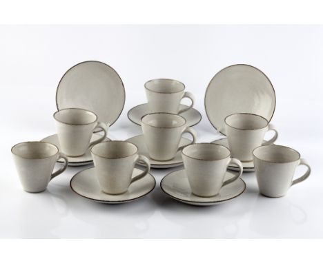Lucie Rie (British, 1902-1995) Set of eight cups and saucers, circa 1955 oatmeal glaze with manganese rims impressed potter's