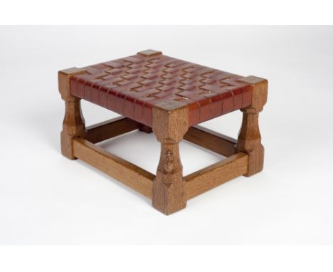 Robert Thompson of Kilburn (British, 1876-1955) Mouseman oak foot stool on octagonal supports and woven leather top carved mo