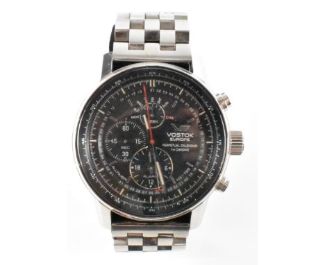 A Vostok Europe stainless steel chronograph wrist watch. The watch having a black face with three subsidiary dials, tachymete