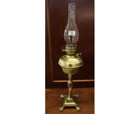 Early 20th Century brass double burner oil lamp with brass reservoir on baluster pedestal with square stepped base on claw fe