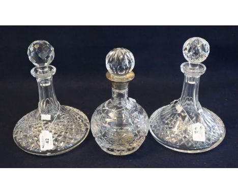 Two similar cut lead crystal glass ship's decanters together with a mallet shaped cut lead crystal spirit decanter with silve