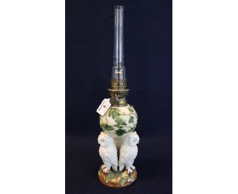 Early 20th Century single oil burner having glass chimney, the ceramic reservoir base decorated with raised ivy and standing 
