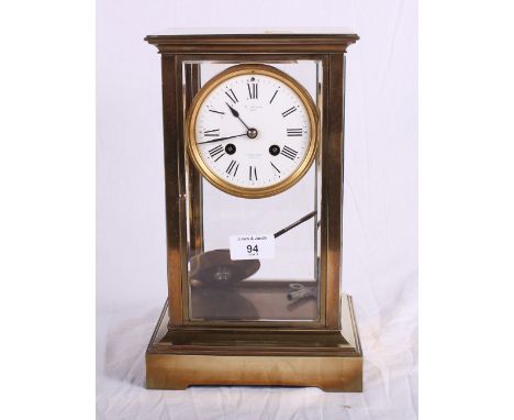 An early 20th Century brass framed mantel clock with bevelled glass sides, white enamel dial inscribed "W ANGUS PARIS", 12" h