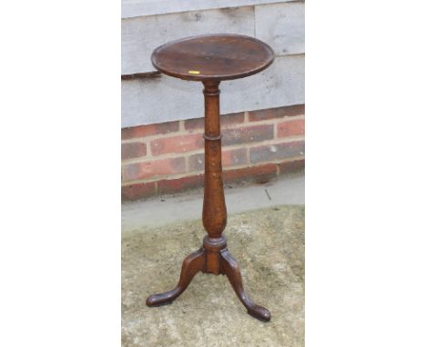 A 19th Century oak candle stand with circular top, on baluster stem and tripod base, 12" dia