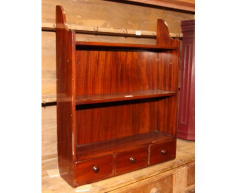 A mahogany wall mounted shelf, fitted three drawers