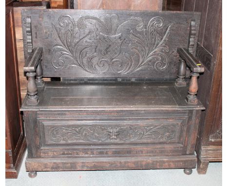 A monk's dark oak bench, box seat with carved panel front, 48" wide