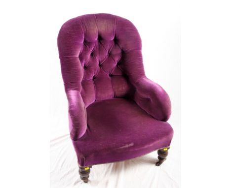 A Victorian armchair, button upholstered in a purple velour, on turned supports