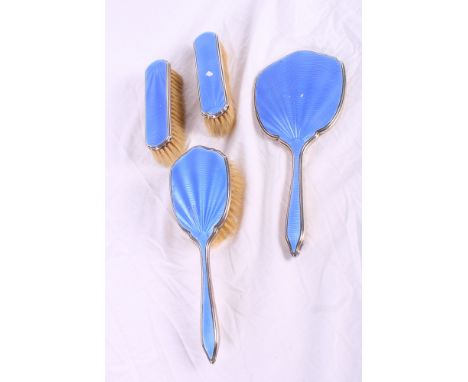 A silver and blue enamel backed hand mirror, a pair of matching clothes brushes and a hairbrush