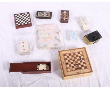 A mother-of-pearl card case, a set of bone dominoes, in case, four miniature sets of playing cards, a miniature drafts set an