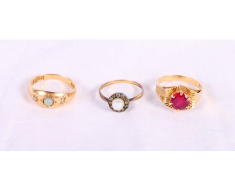 An Edwardian 18ct gold, opal and diamond dress ring, a gold and ruby dress ring and a gold cluster ring