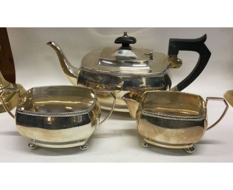 A good silver three piece tea service on four ball feet. Birmingham. Approx. 840 grams. Est. £200 - £300.