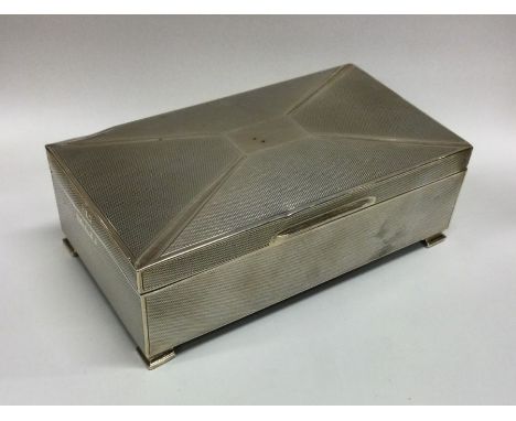 A silver mounted cigarette box of engine turned design. Birmingham. Approx. 443 grams. Est. £50 - £80.