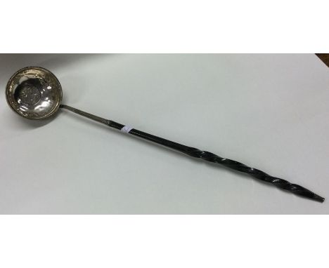 An early 18th/19th Century silver toddy ladle with whalebone handle and early coin to centre. Approx. 47 grams. Est. £30 - £5