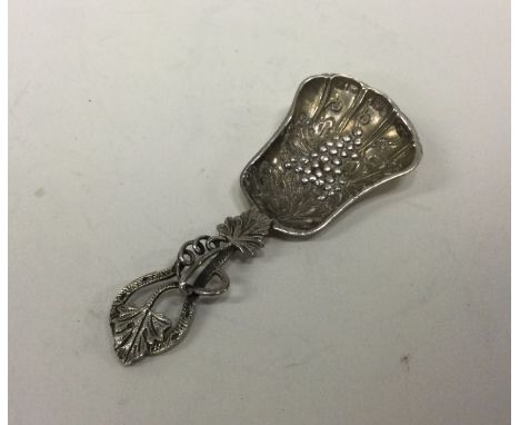 A cast silver caddy spoon mounted with grapes. Birmingham. By DG. Approx. 22 grams. Est. £30 - £50.