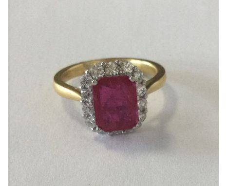 An attractive ruby and diamond cluster ring with cut corners, (the ruby weighing approx. 2.50 carats and the diamonds weighin