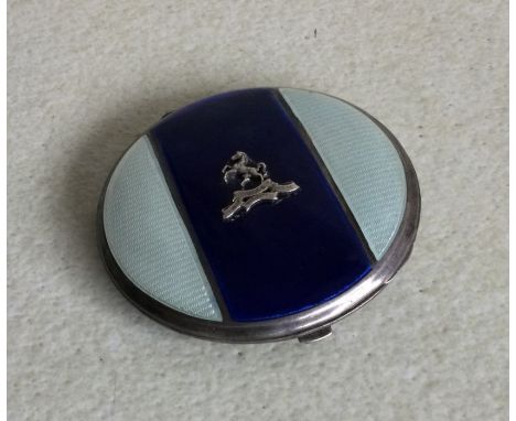 A silver and enamelled compact with engine turned decoration. Approx. 78 grams. Est. £30 - £50.