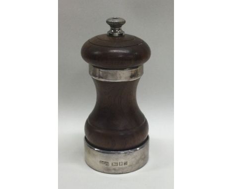 A heavy silver mounted wooden pepper grinder. London 1964. By Peter Gilmore Ltd. Est. £50 - £80.